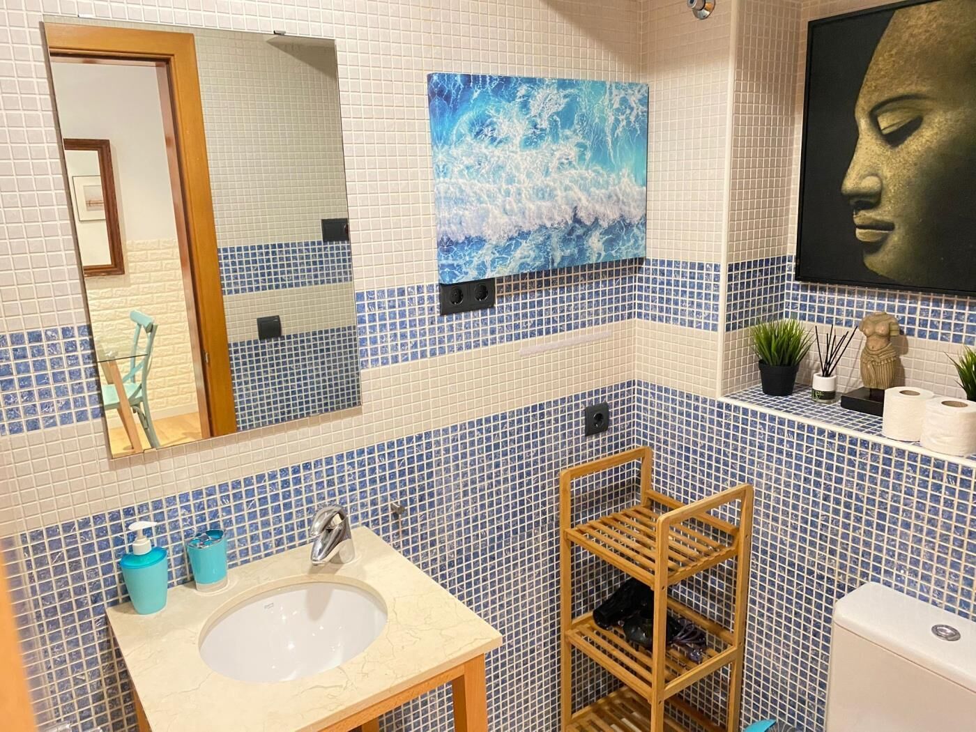 A bathroom with a sink, mirror, and tiled walls.