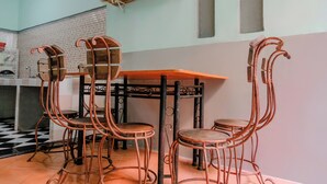 Un comedor con una mesa de madera y cuatro sillas de metal con patas curvas.