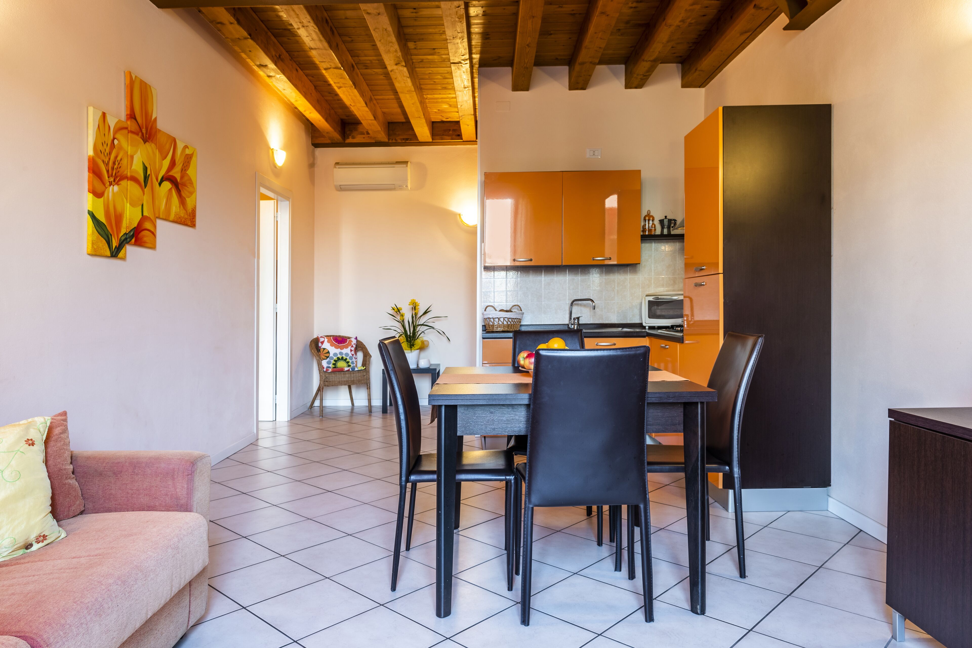 Un comedor con mesa y sillas, un sofá y una cocina al fondo.