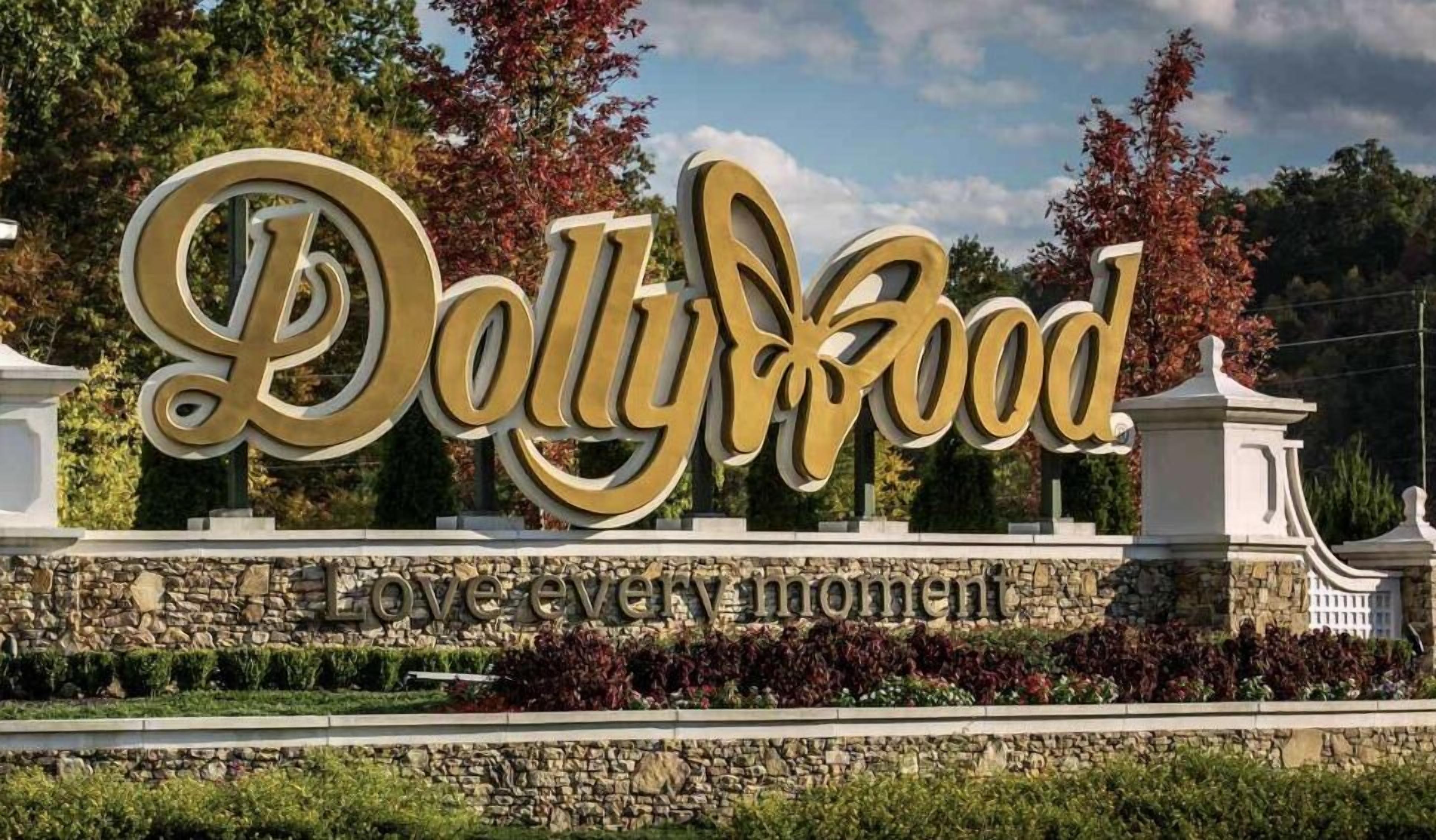 A large, gold-lettered sign for Dollyhood with the tagline "Love every moment" below it.