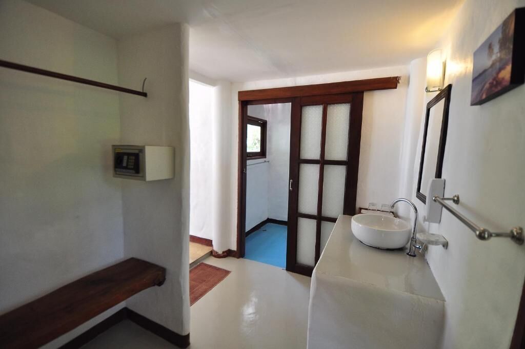 A bathroom with a white sink, a mirror, and a towel rack.
