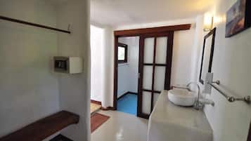 A bathroom with a white sink, a mirror, and a towel rack.