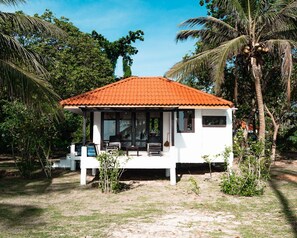 A white building with a red roof, surrounded by palm trees and greenery. - Lazy Day The Resort (Ko Mak)