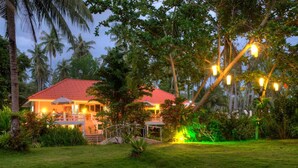 A house with a red roof, surrounded by lush greenery and palm trees. - Lazy Day The Resort (Ko Mak)