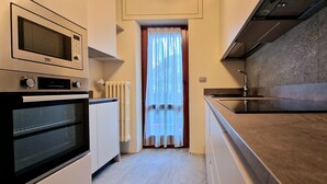Une cuisine équipée d’un four à micro-ondes encastré, d’un four traditionnel et d’une plaque de cuisson moderne.