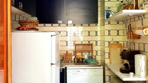 A compact kitchen with a refrigerator, dishwasher, and a coffee maker on the counter. - Monterosa Apartment (Ayas)