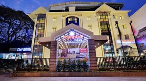 A hotel entrance with a prominent sign reading "Manpho Bell Hotel & Convention Center". - Manpho Bell Hotel & Convention Center (Bengaluru)
