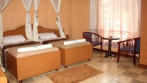A room with two beds, a small table, and a chair.