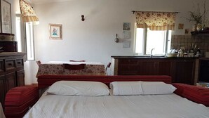 Un dormitorio con una cama grande, un aparador de madera, un escritorio y una ventana con cortinas.