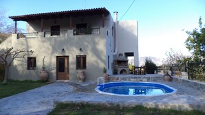 A two-story house with a swimming pool, a balcony, and a stone pathway leading to the pool. - Rural Spacious Villa with Pool at Central Crete (Mylopotamos)