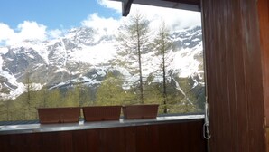 A wooden balcony with three terracotta planters and a view of snow-capped mountains. - La Grande Ourse (Valtournenche)
