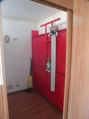 A room with a red wardrobe, a hanging toy, and a yellow cleaning tool. - La Grande Ourse (Valtournenche)