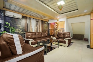 A modern living room with leather sofas, a glass coffee table, and a decorative wall. - Townhouse Oak near Tugu Simpang Lima formerly GM Inn Hotel (Banda Aceh)