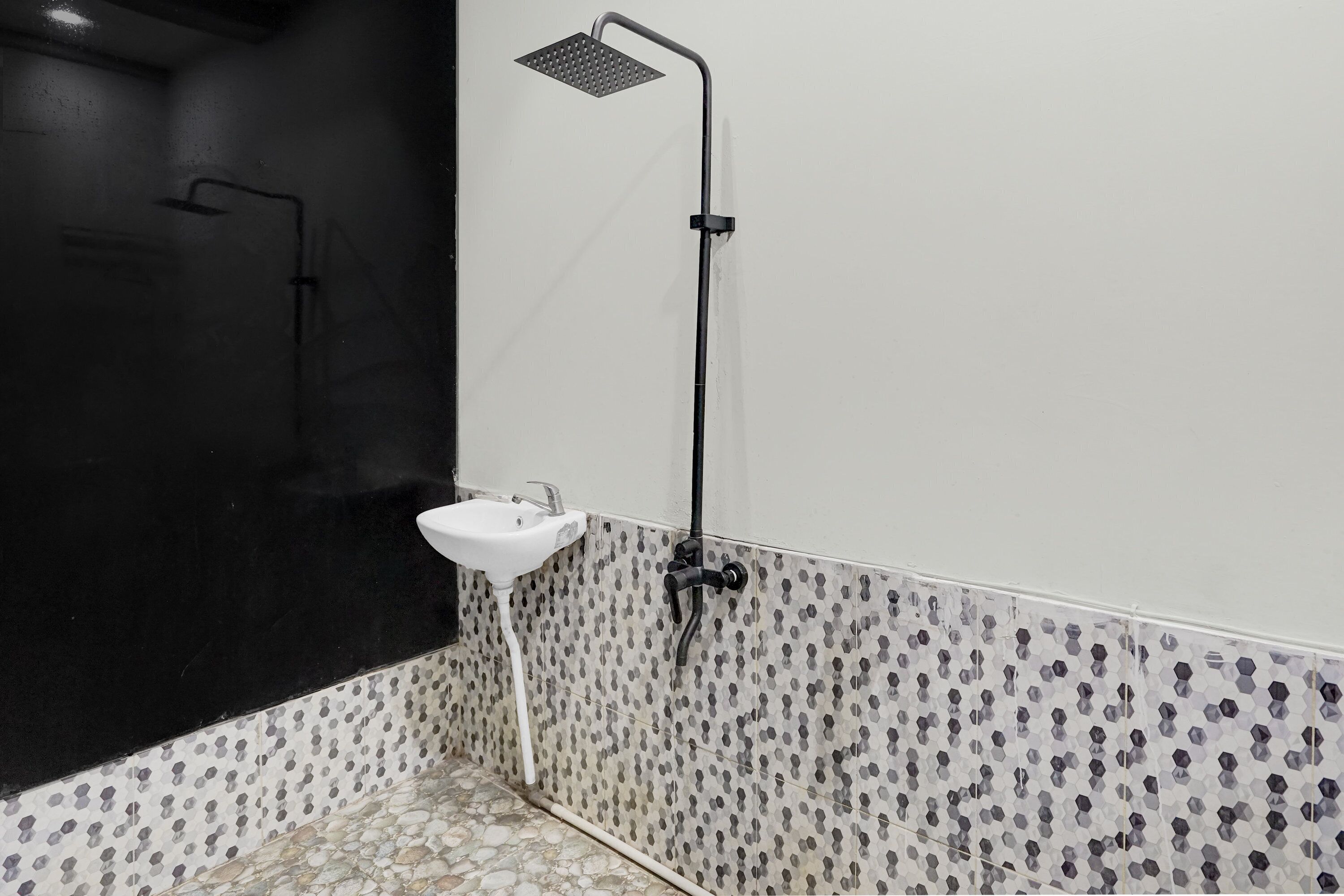 Ein Badezimmer mit Dusche, Waschbecken und fliesenbesetztem Boden.