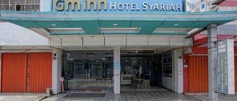 A hotel entrance with a sign reading 'Gmnn Hotel Syariah.'