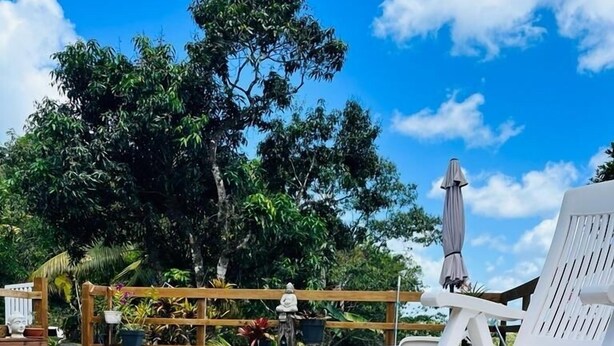A wooden deck with a pool, white lounge chairs, and a statue. - Sweet Pea F2 flirtatious in the countryside (Fort de France)