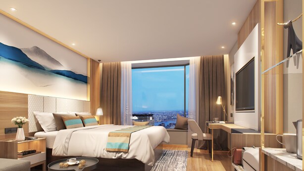 Une chambre d’hôtel moderne avec un grand lit, un bureau et une vue sur la ville.
