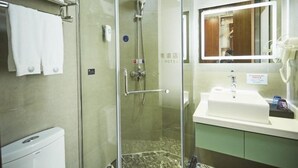Une salle de bain moderne avec une douche à parois de verre, un lavabo blanc et un miroir au-dessus du lavabo.