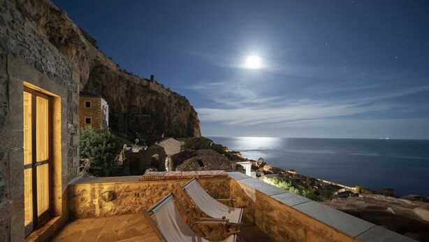 Un bâtiment en pierre doté d’un balcon offrant une vue sur la côte.