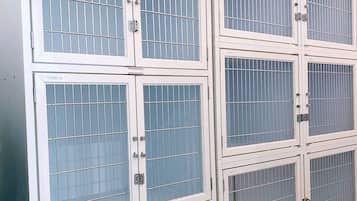 Sechs weiße Metallschränke mit Glastüren, jeweils mit der Kabinennummer von 01 bis 06 beschriftet.