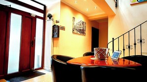 Un comedor con una mesa y sillas, un reloj y un cuadro en la pared.