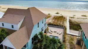 A beachfront property with a swimming pool, lounge chairs, and a view of the ocean. - Spacious 4 Bedroom Gulf Front Home with large deck overlooking Gulf of Mexico (Port Saint Joe)
