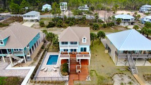 A large house with a pool, a deck, and a covered patio. - Spacious 4 Bedroom Gulf Front Home with large deck overlooking Gulf of Mexico (Port Saint Joe)