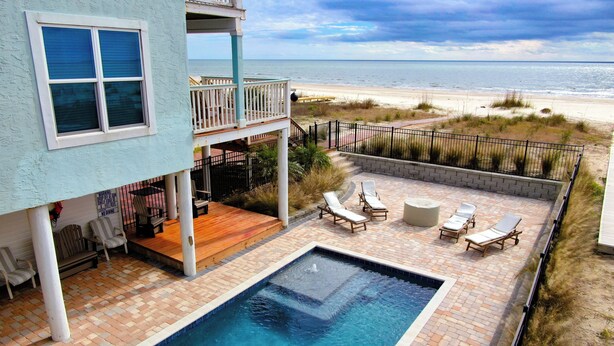 A pool area with lounge chairs and a view of the beach. - Spacious 4 Bedroom Gulf Front Home with large deck overlooking Gulf of Mexico (Port Saint Joe)