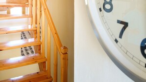 Eine Holztreppe mit einer Uhr an der Wand.