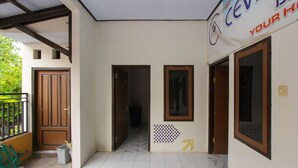 Un couloir avec un sol carrelé, une porte en bois et une pancarte sur laquelle on peut lire : « CEVIC, VOTRE MAISON ».