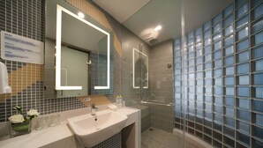 A modern bathroom with a glass shower enclosure, a large mirror, and a sink with a vanity. - Holiday Inn Express Qingdao Innovation Park by IHG (Qingdao)