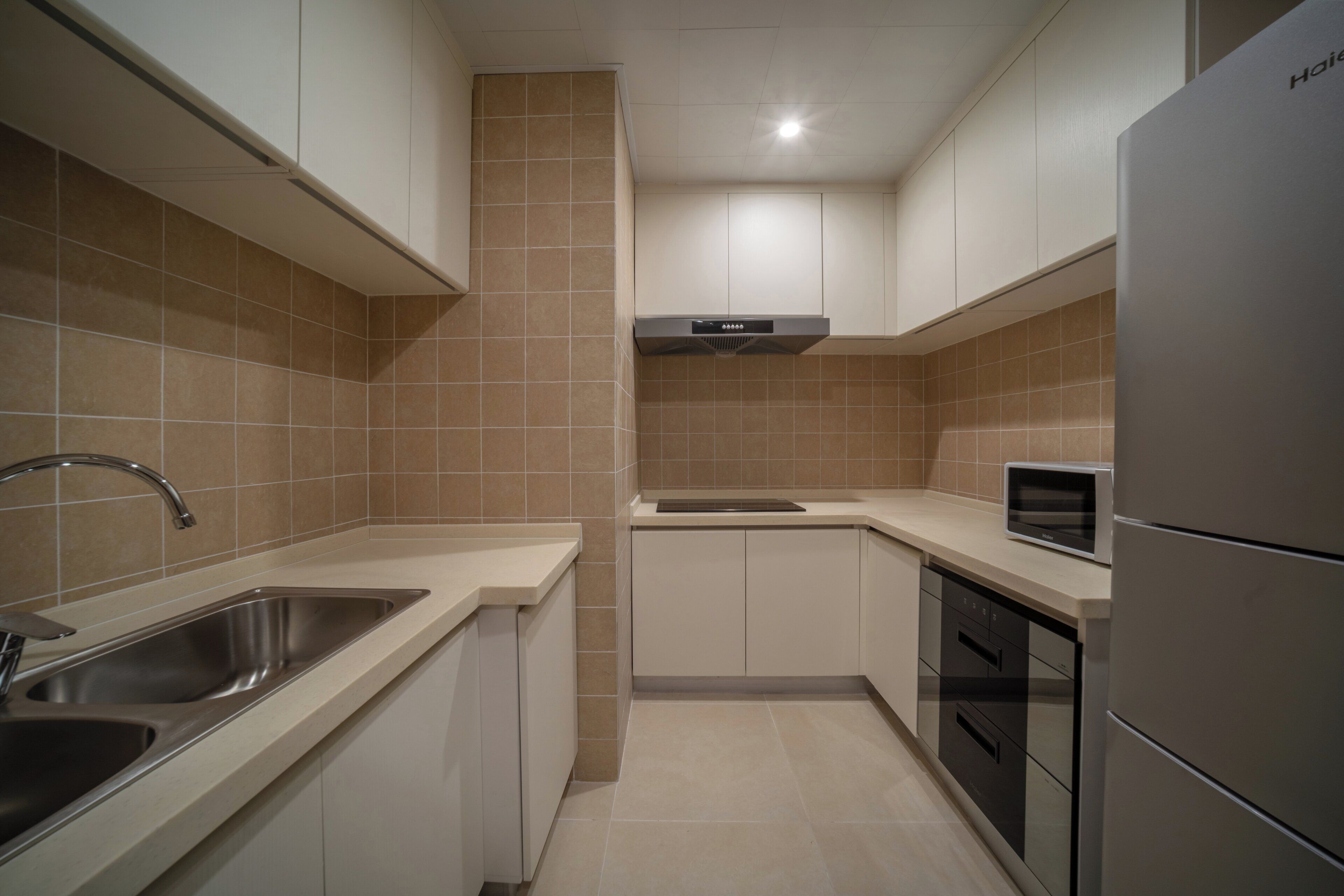 A modern kitchen with stainless steel appliances, a built-in oven, and a microwave.