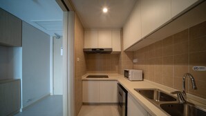 A modern kitchen with a microwave, sink, and ventilation hood. - Holiday Inn Express Qingdao Innovation Park by IHG (Qingdao)