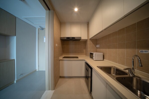 A modern kitchen with a microwave, sink, and ventilation hood. - Holiday Inn Express Qingdao Innovation Park by IHG (Qingdao)