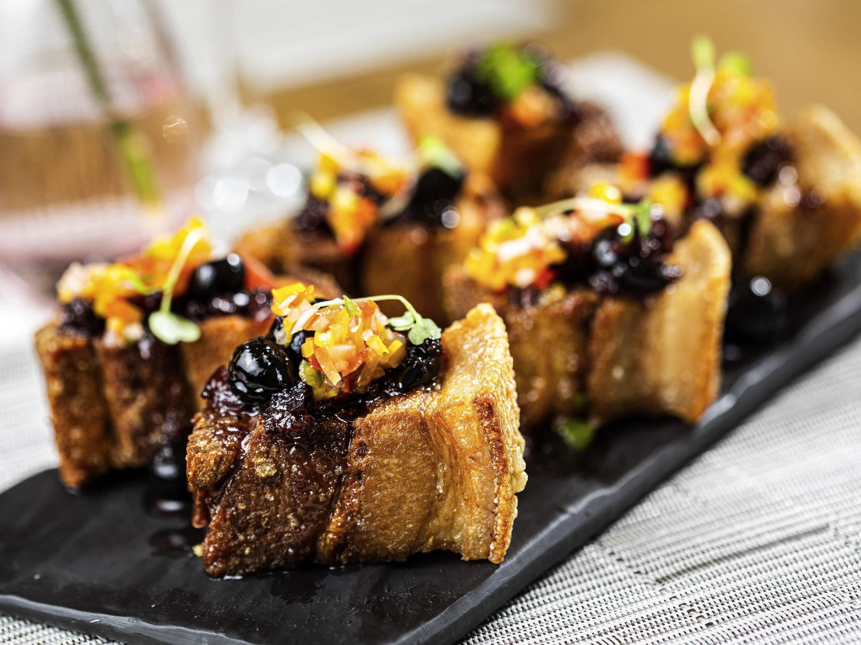 A black slate serving dish with food items.