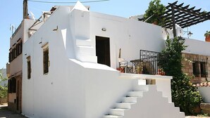 Ein weißes Gebäude mit einer Treppe, die zu einem Balkon führt.