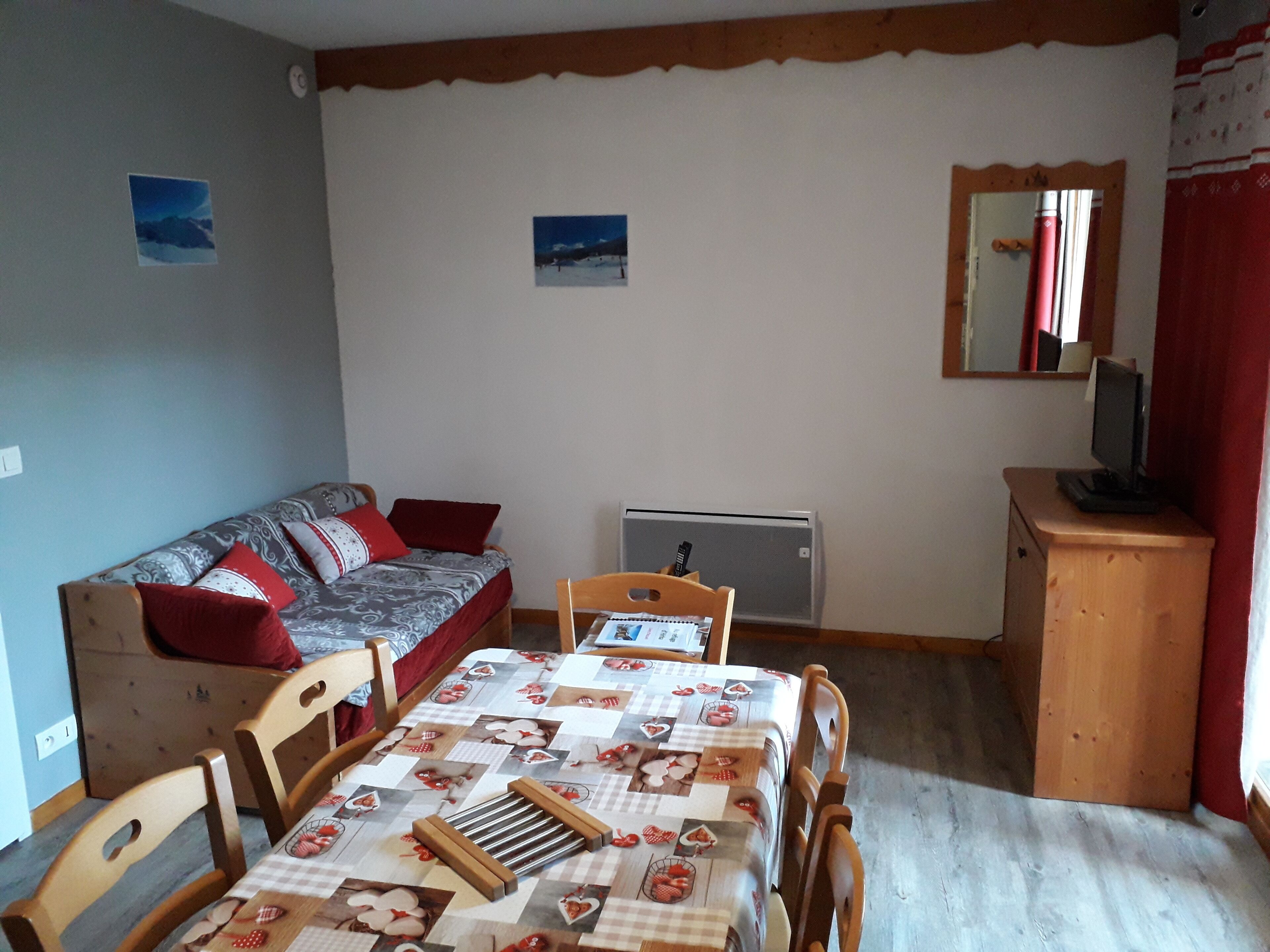 Une petite pièce agréable et confortable, avec un lit, un bureau, une chaise, un radiateur et un téléviseur.