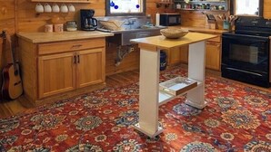 A cozy kitchen with wooden cabinets, a coffee maker, a microwave, and a stove.