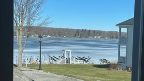 A view of a lake with a gazebo and a lamp post in the foreground.