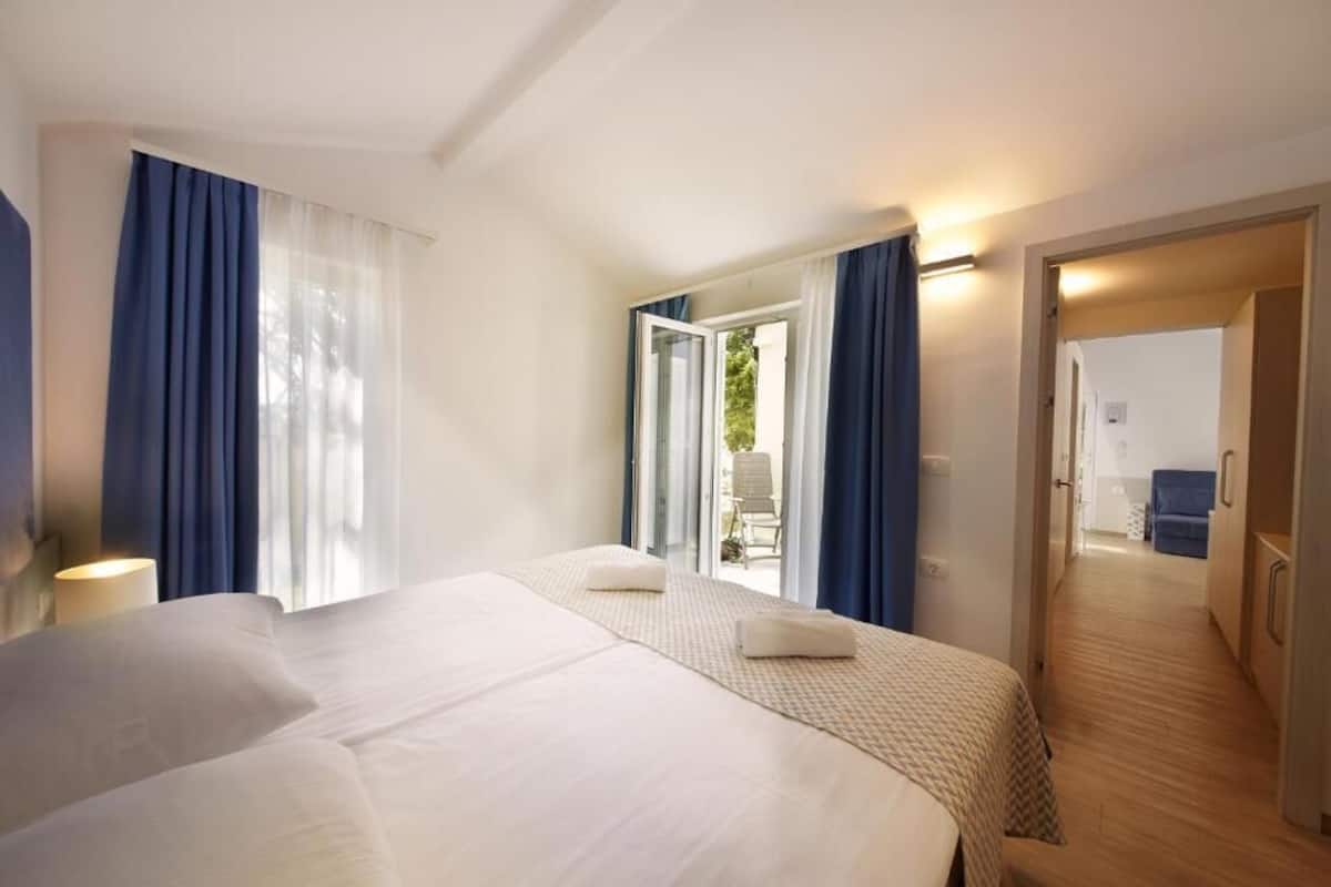A hotel room with a large bed, a desk, and a view of the outdoors.