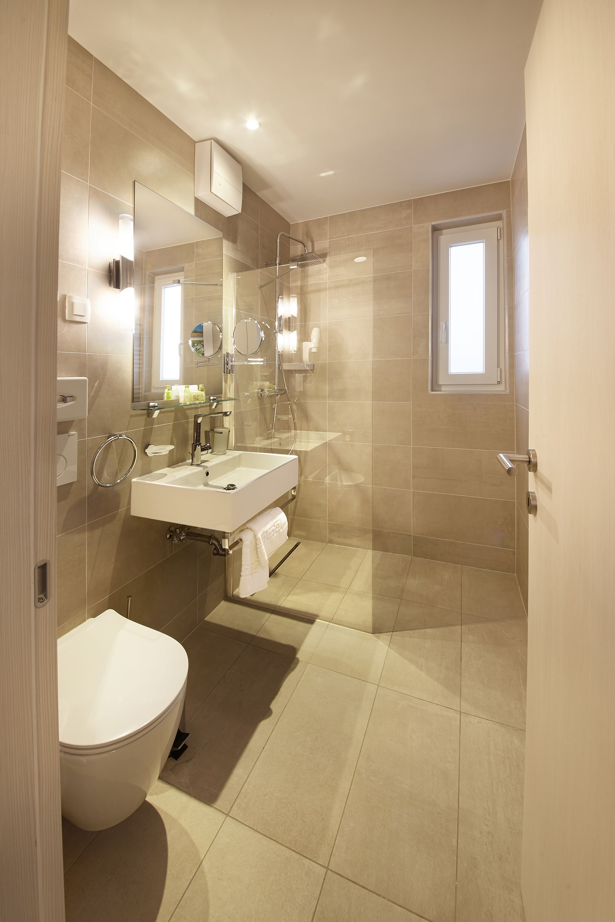 A modern bathroom with a toilet, sink, and shower area.