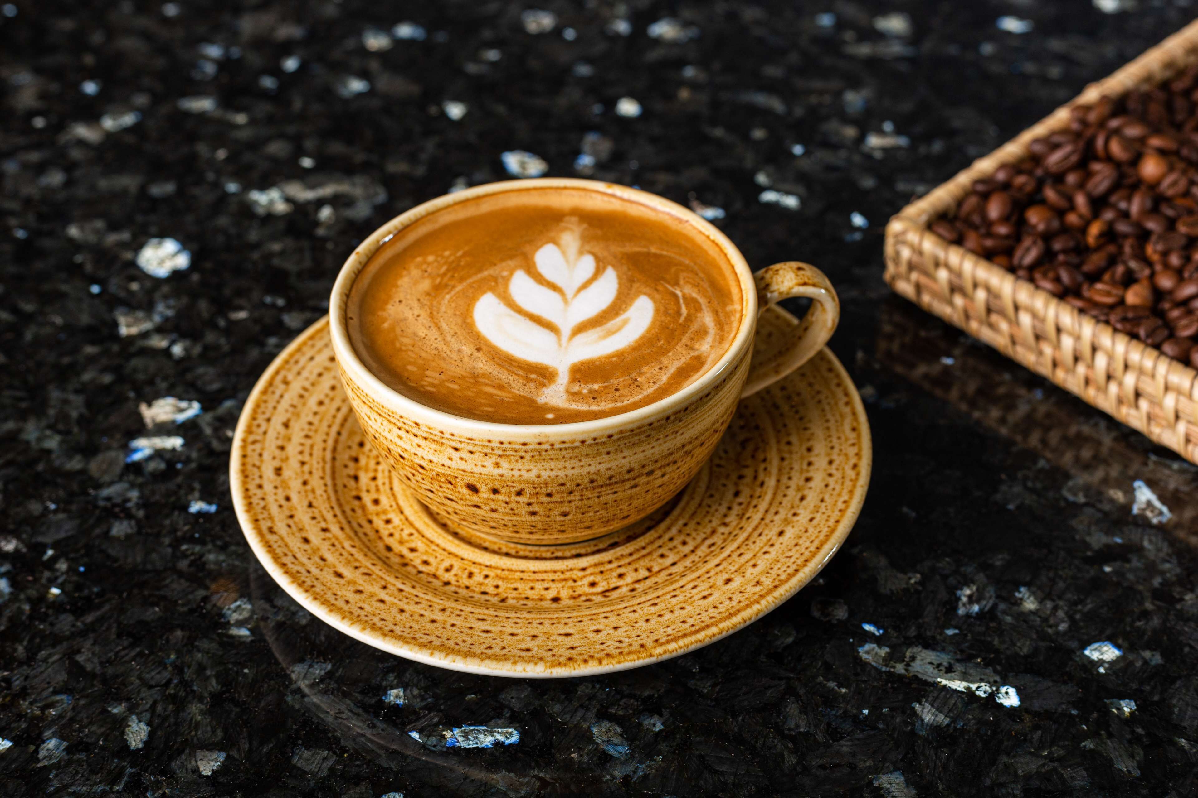 Una taza de café con arte de leche sobre una superficie con textura.
