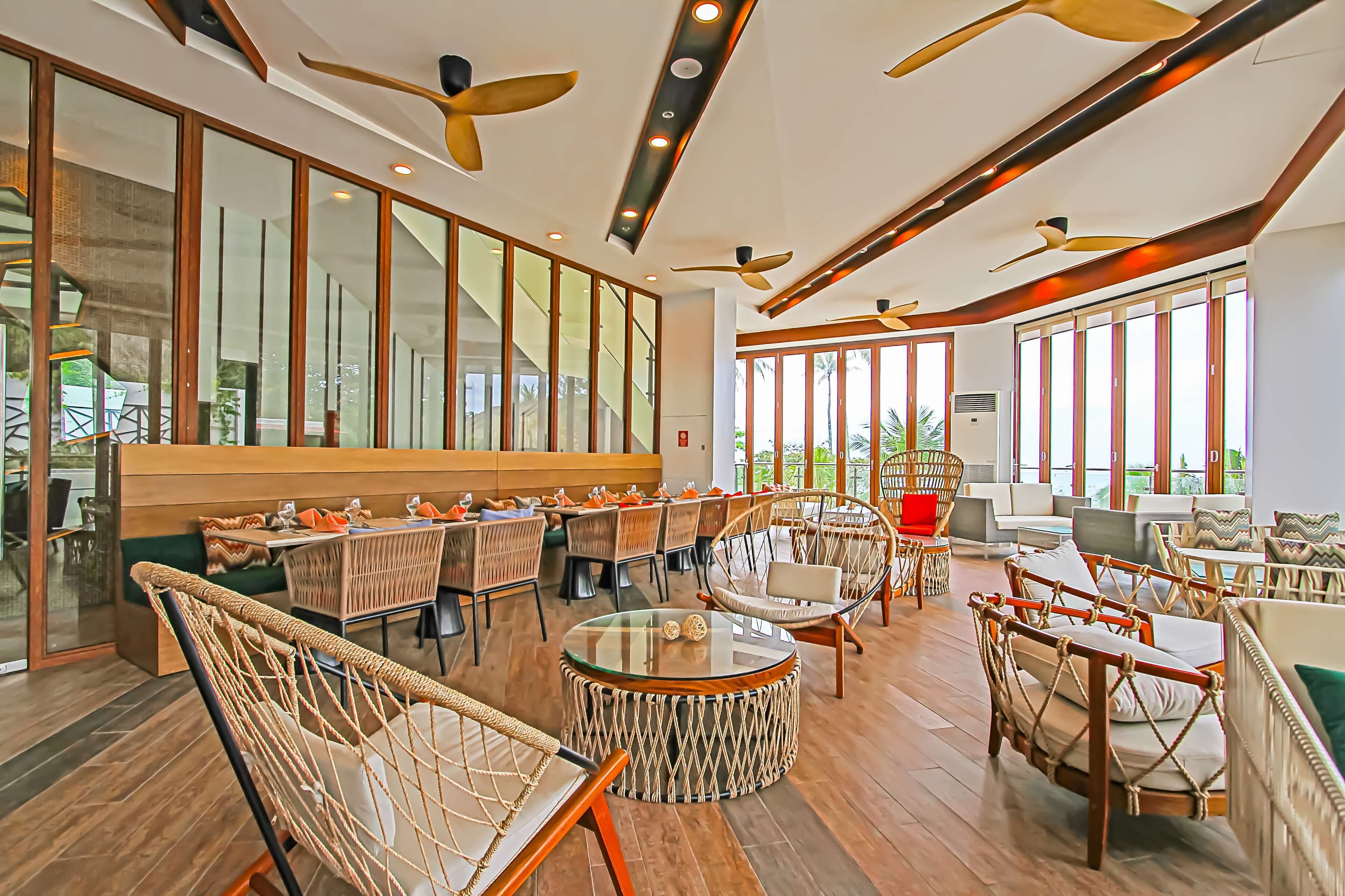 Un espacio interior amplio con techos altos, ventanas grandes y muebles modernos.