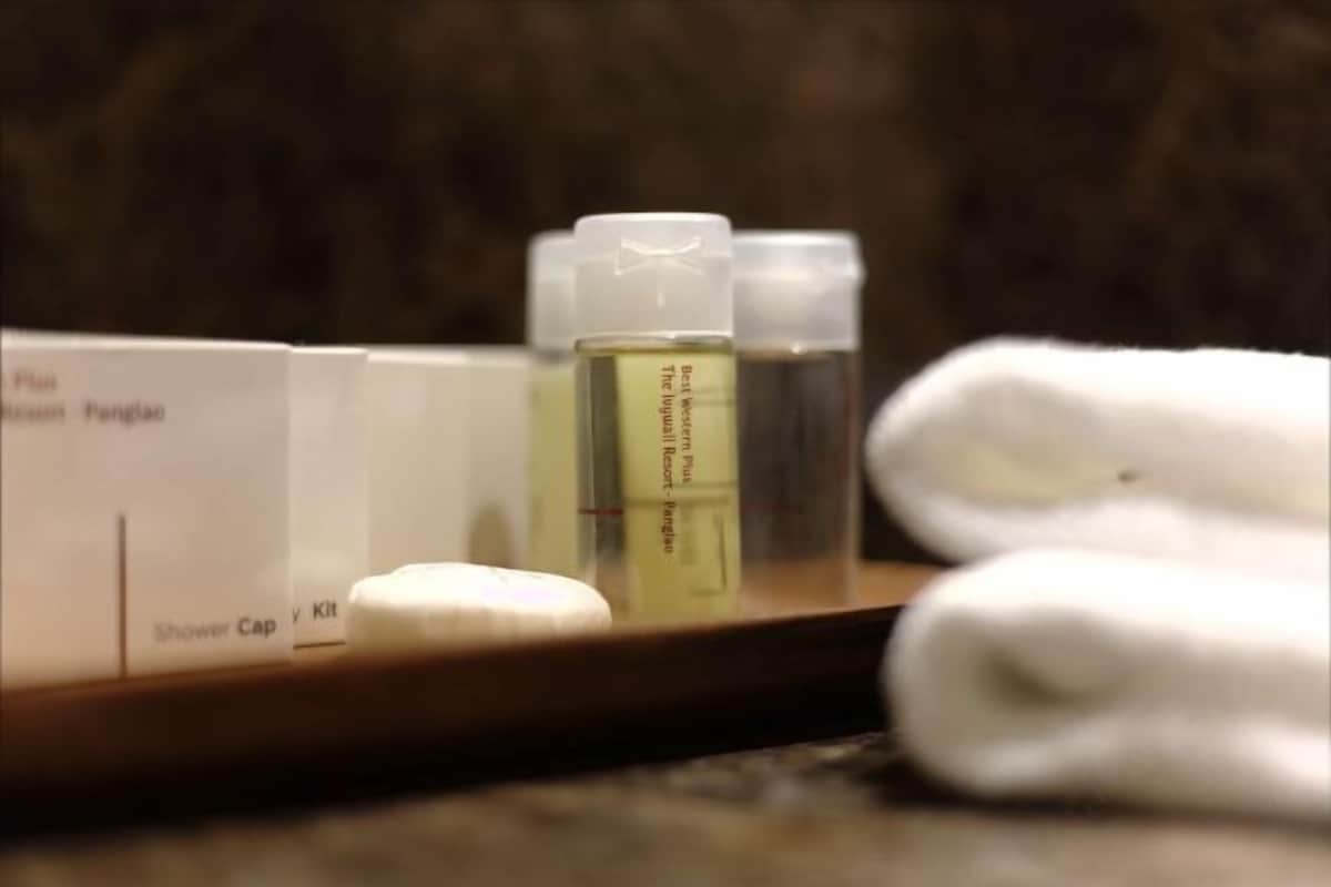 A bathroom with a shower cap, a bottle of shampoo, and a towel.