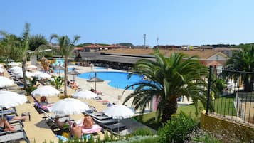 Een buitenzwembad, parasols voor strand/zwembad