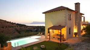 A stone house with a swimming pool, outdoor seating, and a view of the sea. - Villa Patriko Lux villa with pool next to Balos (Kissamos)
