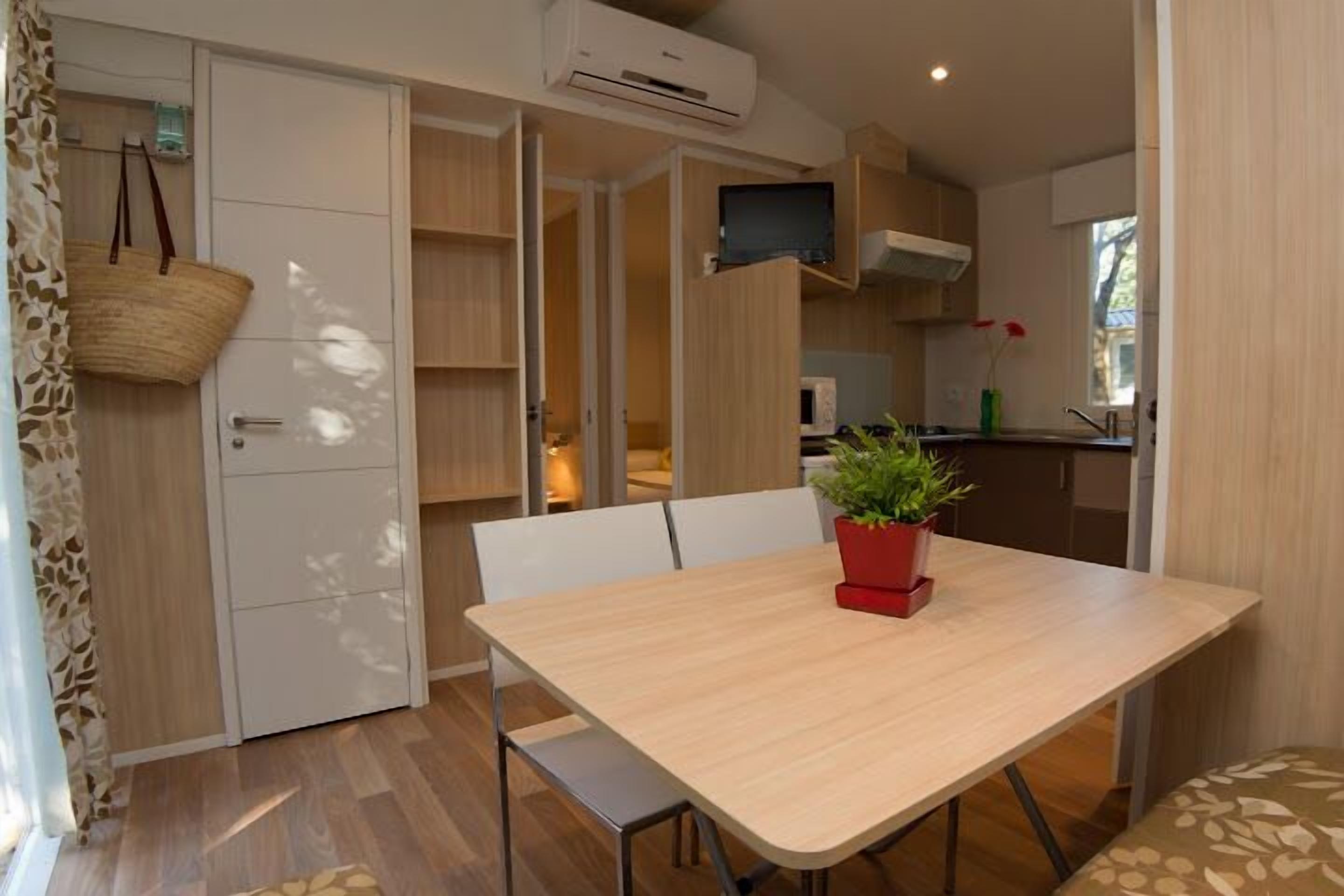 A compact kitchen with a microwave, a TV, and a window.