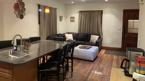 Un espacio habitable compacto con área de cocina, una mesa de comedor y un sofá.