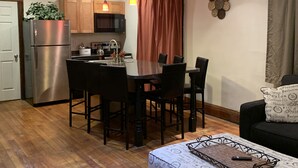 Un espacio habitable compacto con kitchenette, comedor y zona de estar.