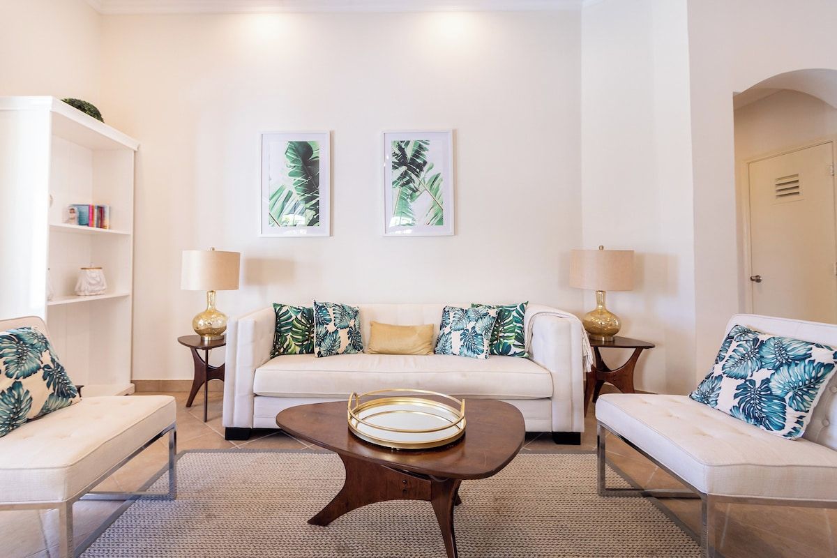 A living room with a sofa, two side tables, a coffee table, and a bookshelf.
